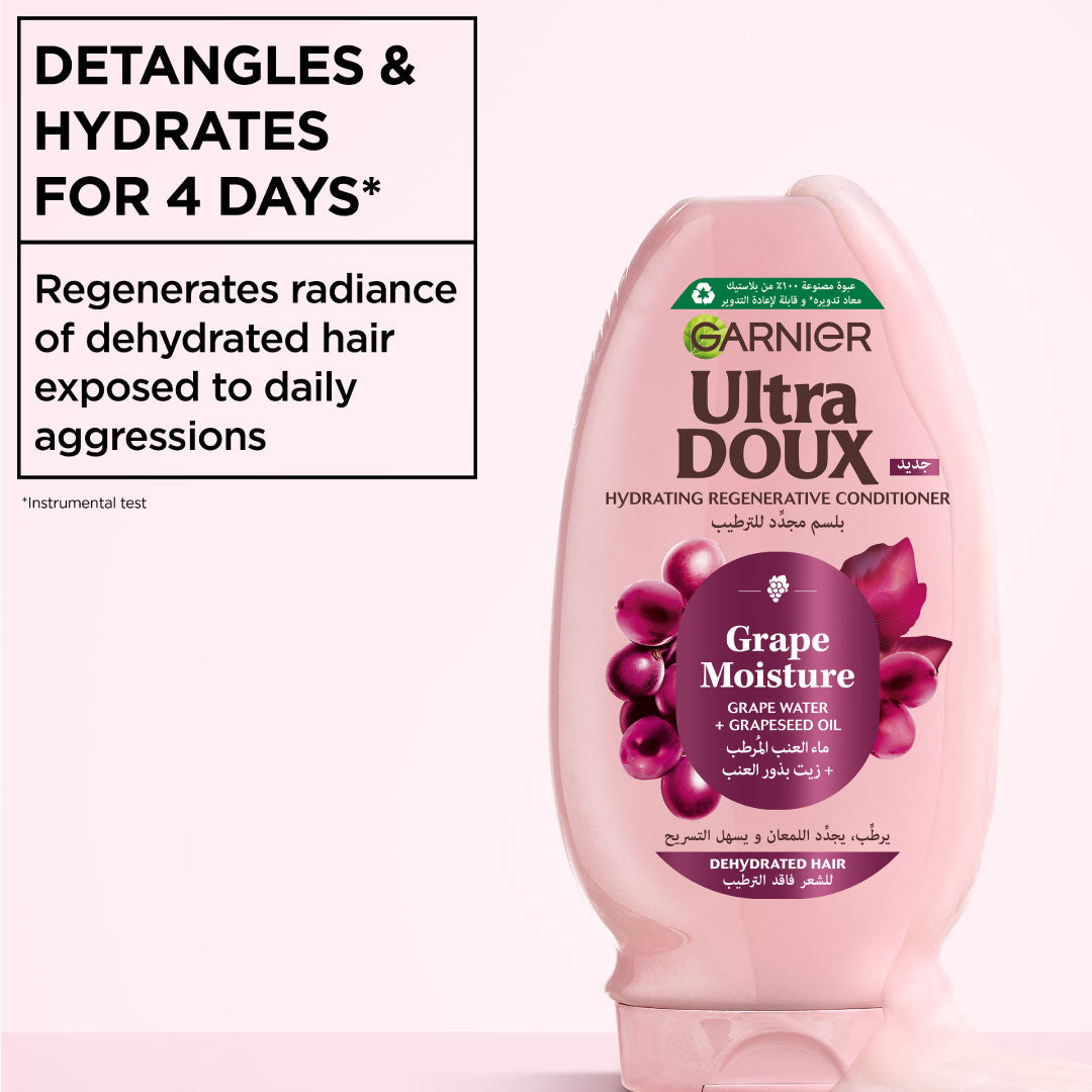 Garnier Ultra Doux Grape Moisture conditioner bottle on a pink background with text about hair care benefits.