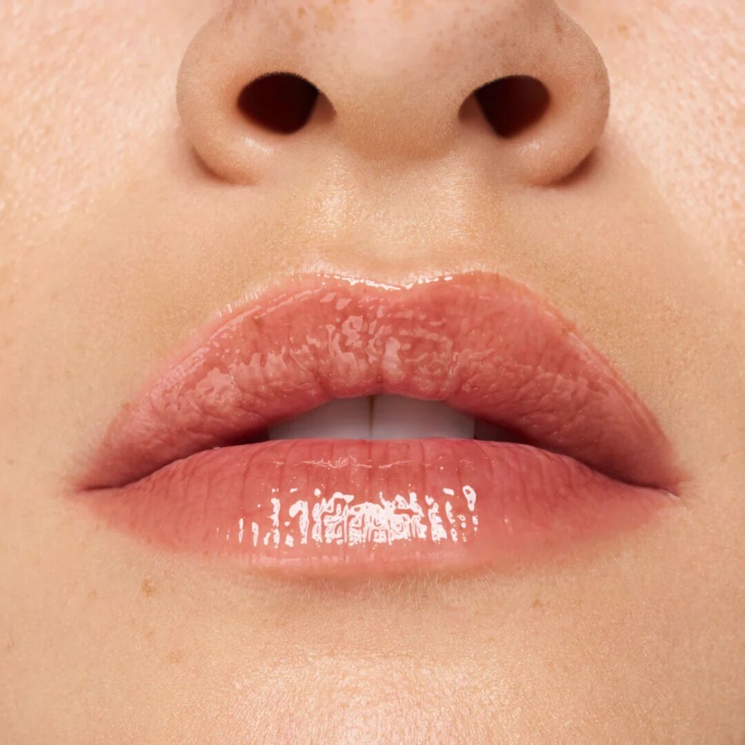 Close-up of a person's lips with Essence Choco Bomb Lip Gloss applied
