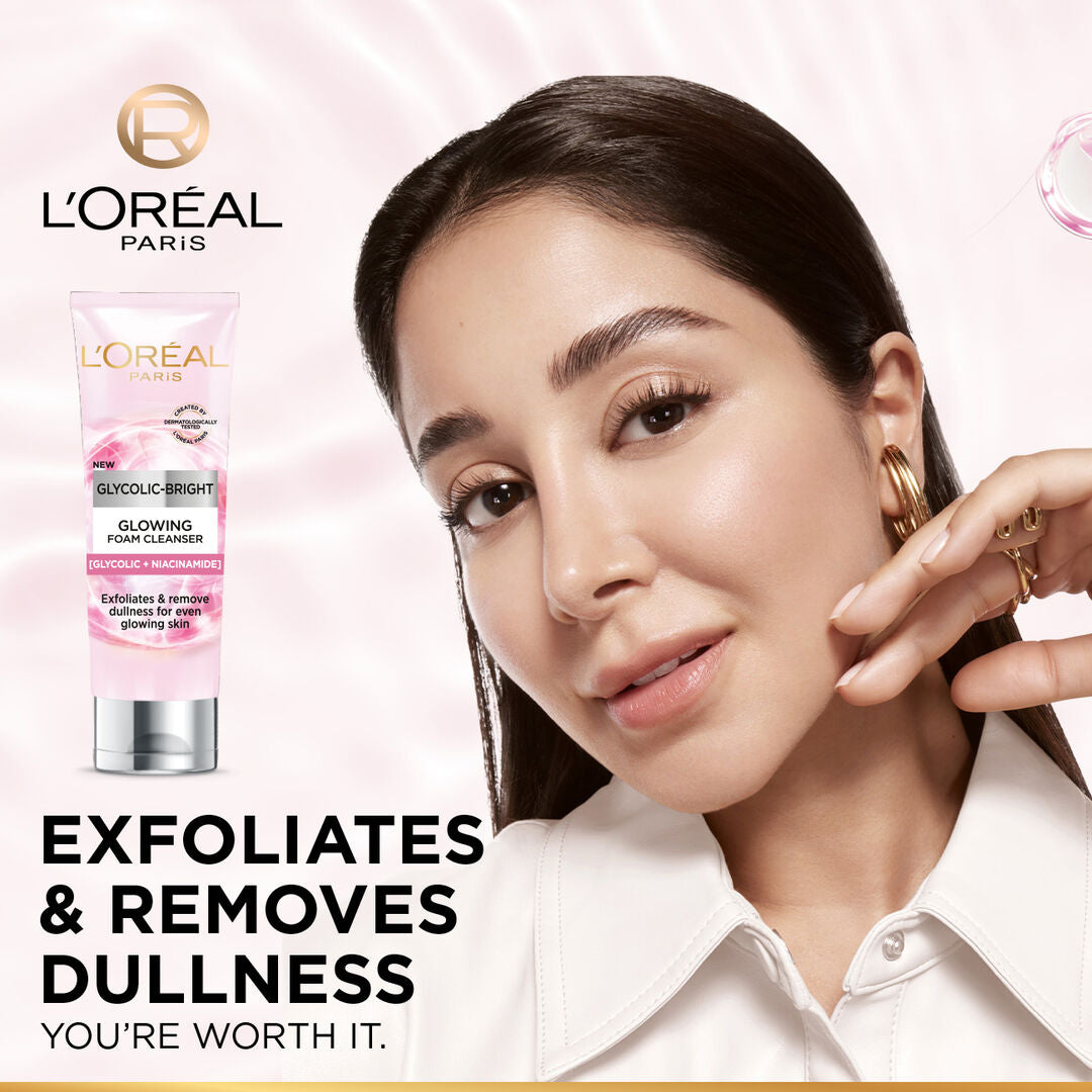 Woman applying cream to her face with L'Oreal product in the background