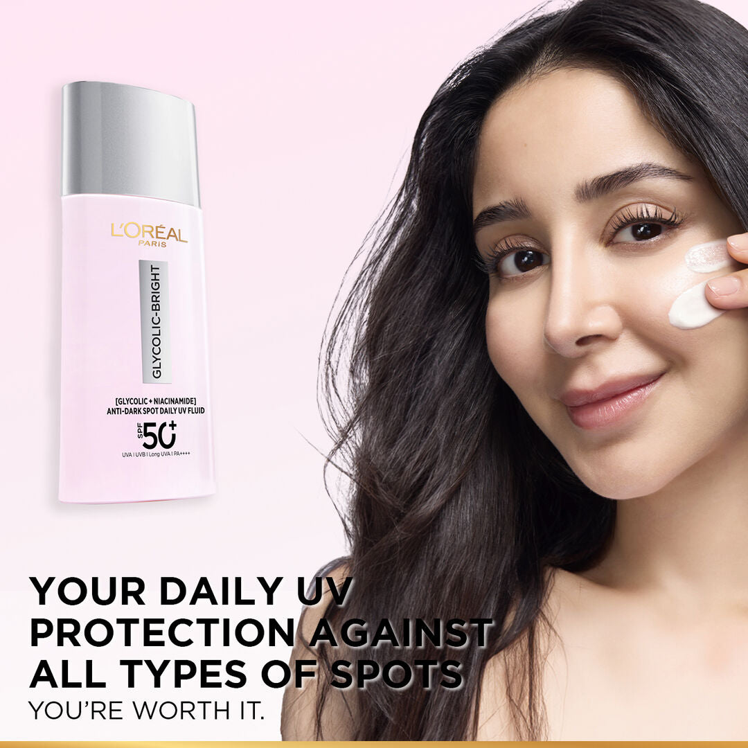 Woman applying sunscreen with L'Oreal bottle in the background